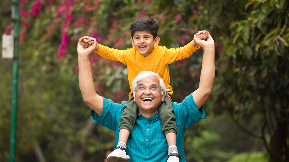 An older man with a child on his shoulders