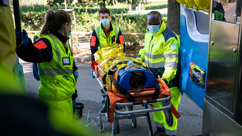 three paramedics assisting person on gurney 