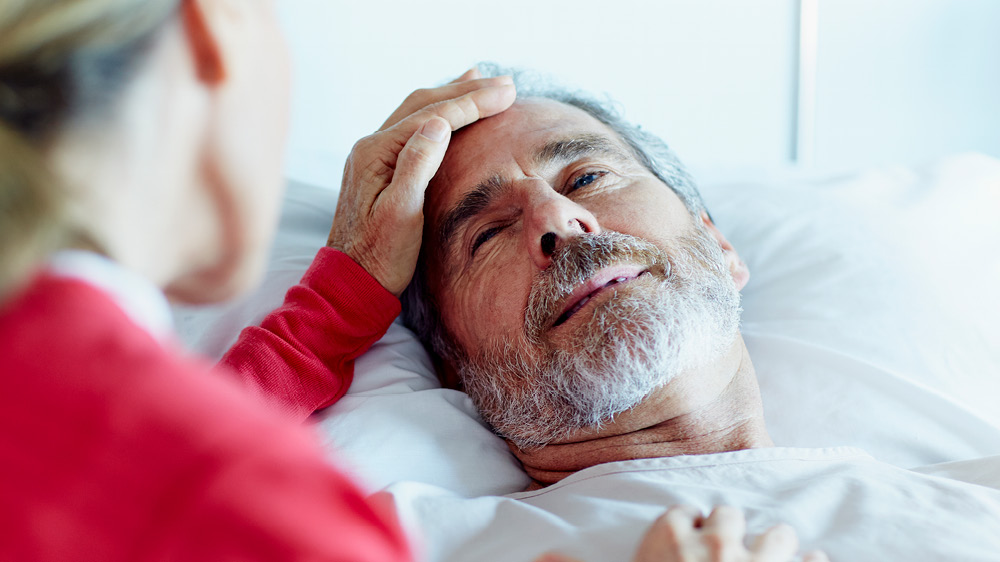 man laying in bed with a head injury