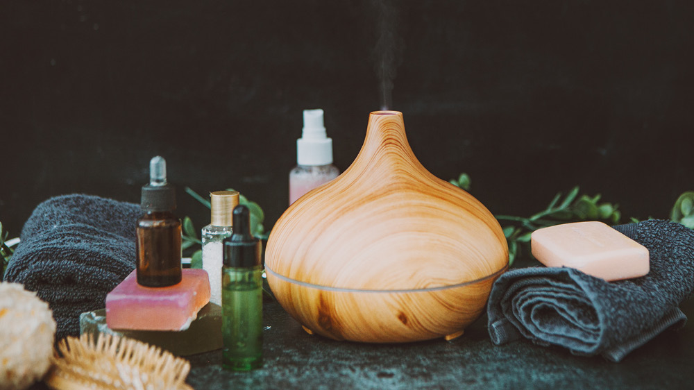 essential oils, diffuser and body balm organized in a row