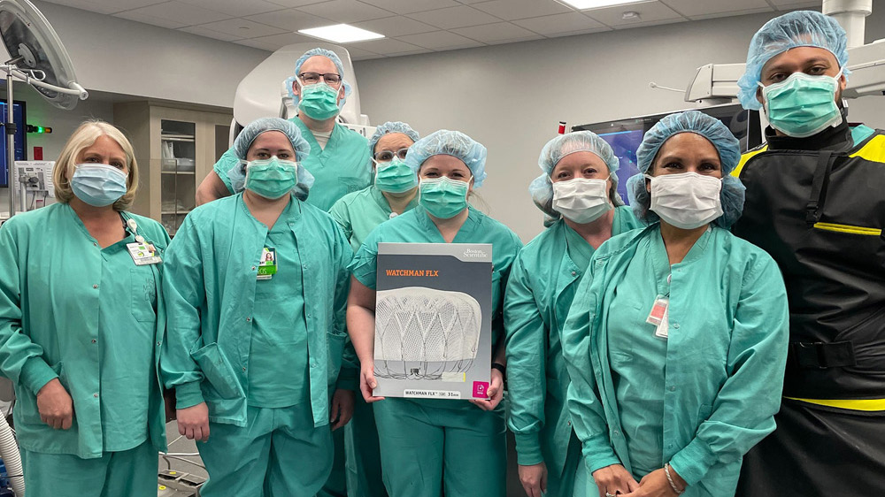 group of cardiovascular health care colleagues holding box of WATCHMAN implant devices