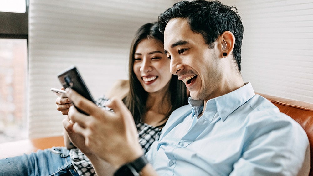 young man with hearing aid sitting on couch with young woman