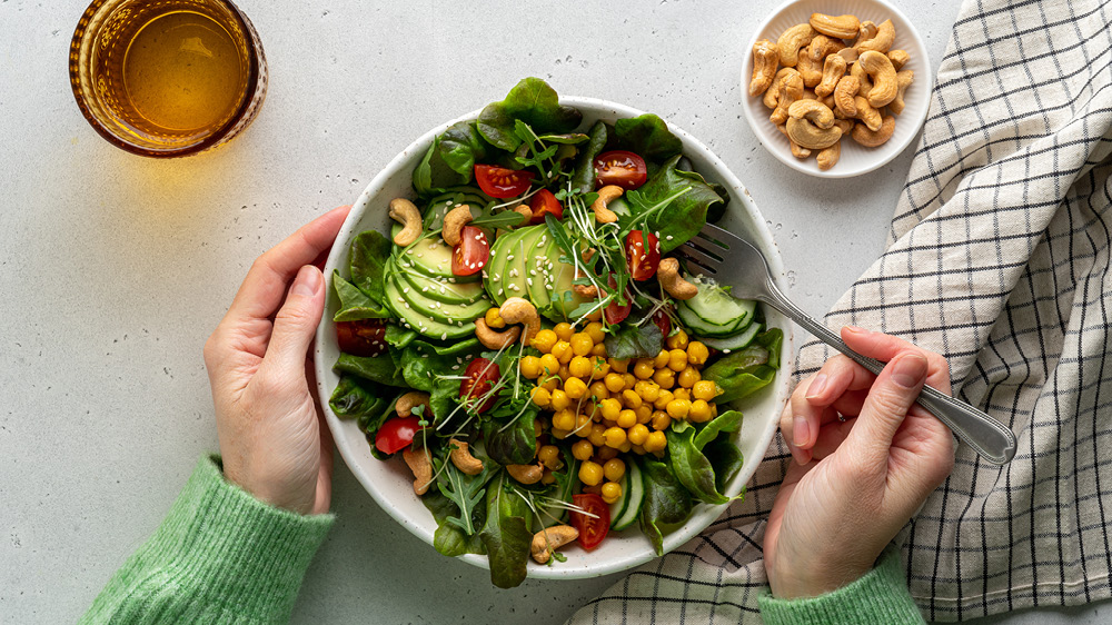 colorful salad on countertop with glass of water