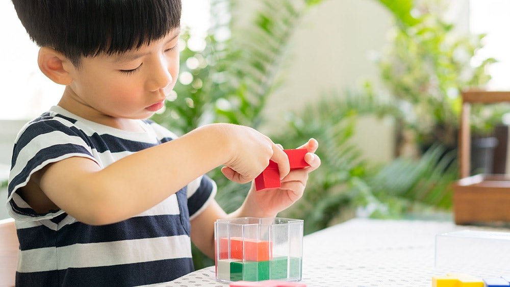 young child playing with building blocks