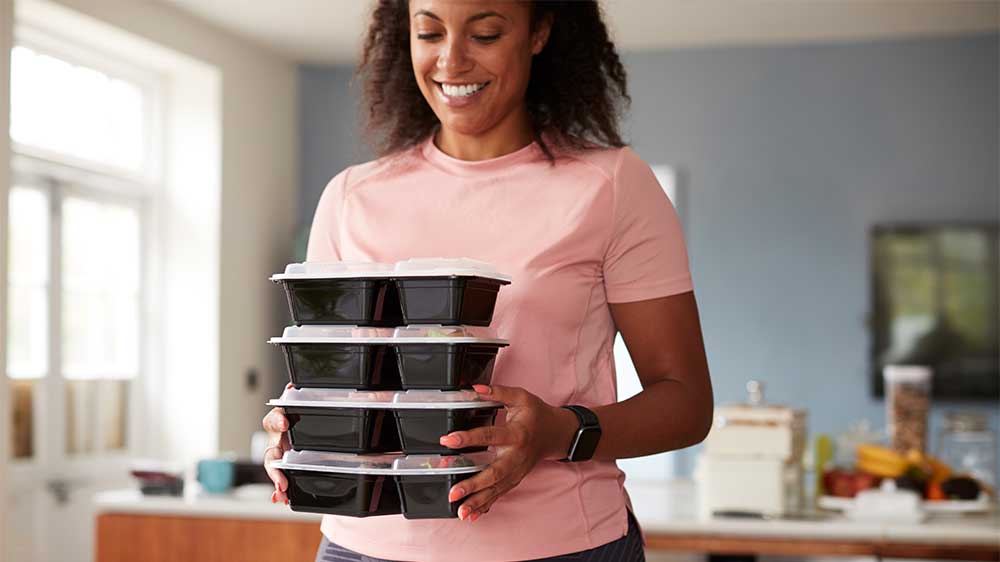 woman holding her meal prep kits