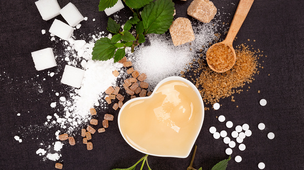 different types of artificial sweeteners on a table with coffee in a heart mug