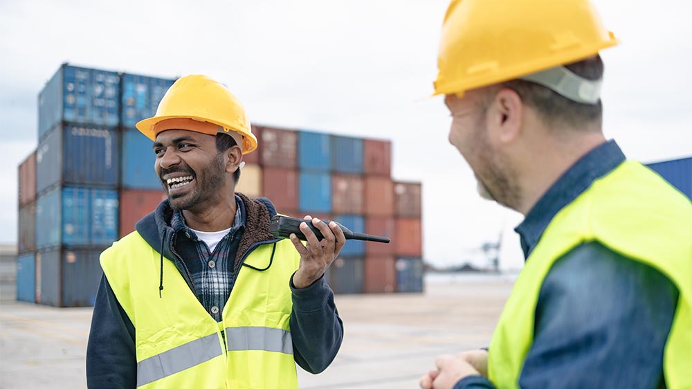 two construction workers talking and smiling