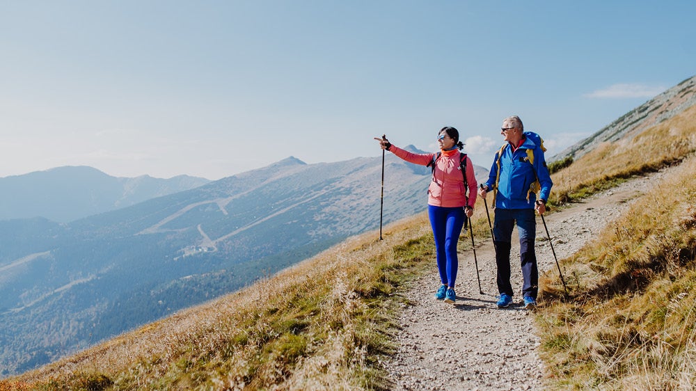 two people hiking a trail in high altitude.