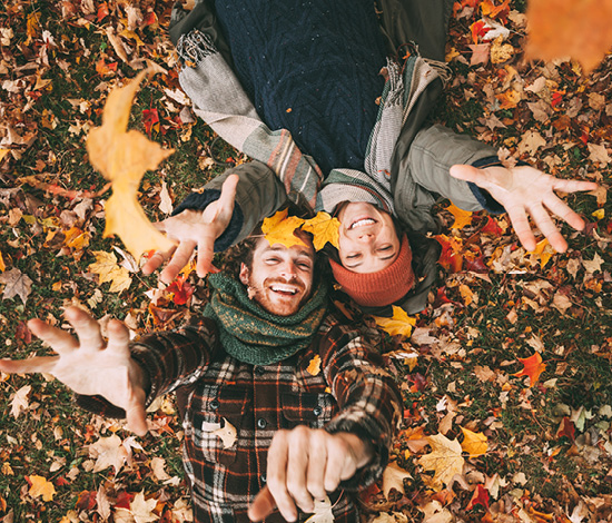 couples playing in fall leaves