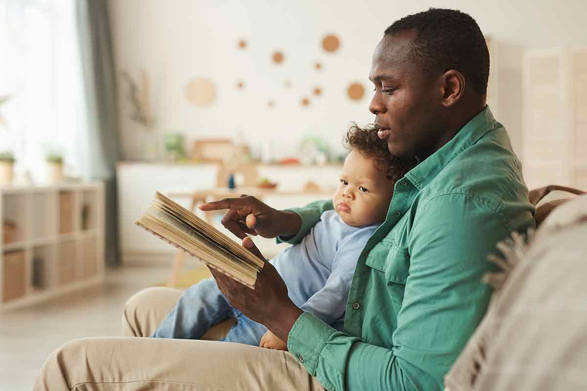 man sitting with infant reading book