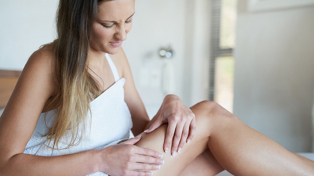 Woman inspecting her thigh