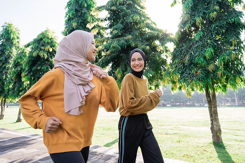 two young women running and smiling